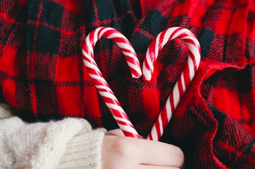 vrouw vormt hartje met candycanes om liefde tijdens kerst aan te geven